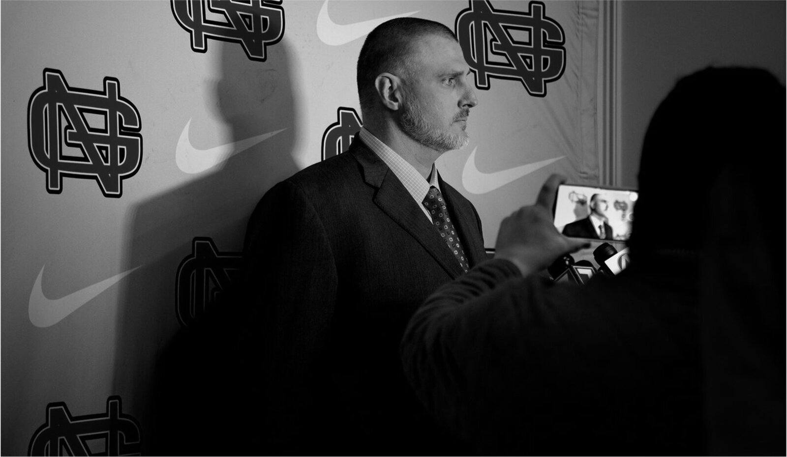 Nate Garner at a head coach press conference, black and white